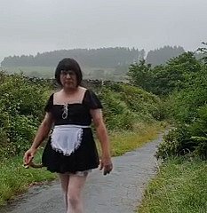 Femme de ménage travestie dans une voie publique sous numbing pluie